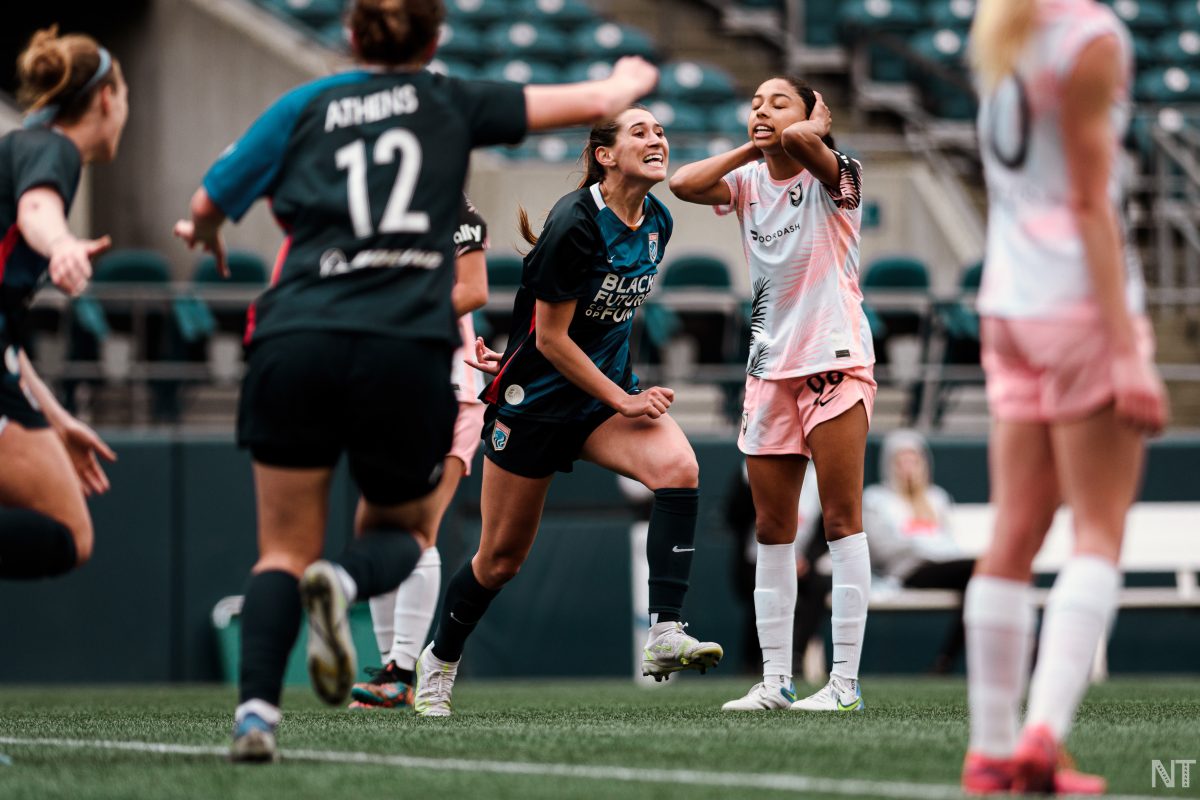 Olivia van der Jagt (center in dark blue OL Reign kit) celebrates a goal against Angel City FC. (Photo by Nikita Taparia)