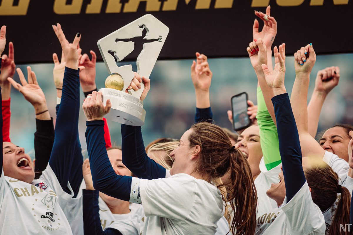 Members of the Washington Spirit lift the National Women's Soccer League trophy. (Photo by Nikita Taparia)