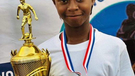 Mogbwemo Queens FC's Rachael Alieu holds the Sierra Leone Women's Premier League trophy and her winner's medal.